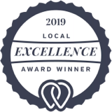 Circular badge with dark border reads 2019 Local Excellence Award Winner in the center, featuring a stylized heart design at the bottom.
